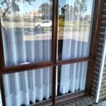 Professionally stained walnut timber window frames on a residential house exterior by S and R Painting Group in Lynbrook.