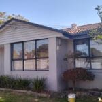 Professionally painted modern residential house exterior with light grey render walls and dark window trim by S and R Painting Group in Springvale VIC.