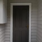 Professionally painted dark woodland grey front entry door with crisp white trim and shale grey weatherboard cladding by S and R Painting Group in Ringwood.